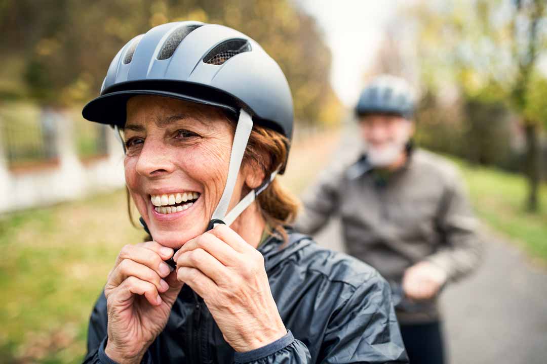Older woman buckling a bike helmet